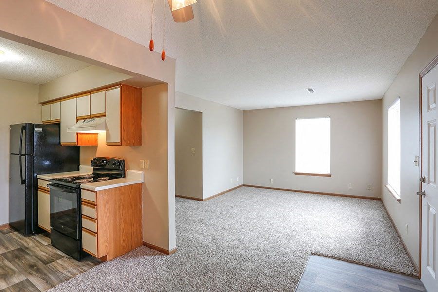 an empty kitchen and living room with a stove and refrigerator