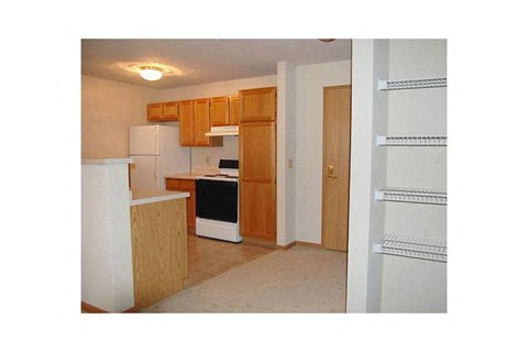 A kitchen with wooden cabinets and a white refrigerator.