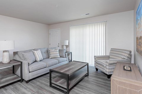 A living room with a grey couch, a chair, and a coffee table.