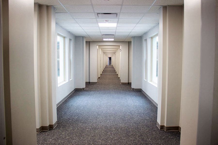 an empty hallway in an office building with a carpeted floor