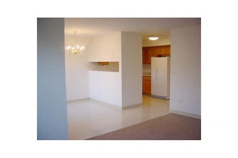 A room with a white wall and a chandelier.