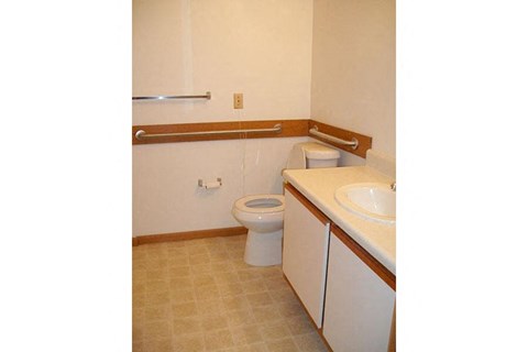 A white toilet sits next to a sink in a small bathroom.