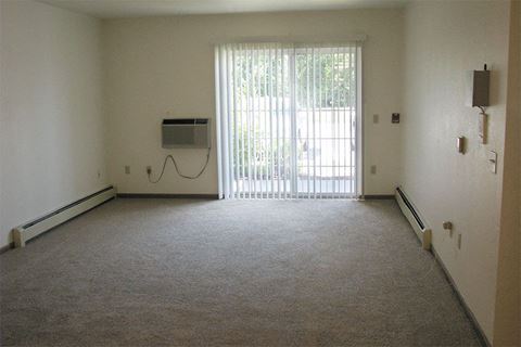 an empty room with a heater and a window