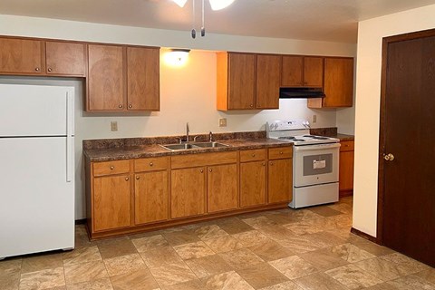 A kitchen with wooden cabinets and a white refrigerator.
