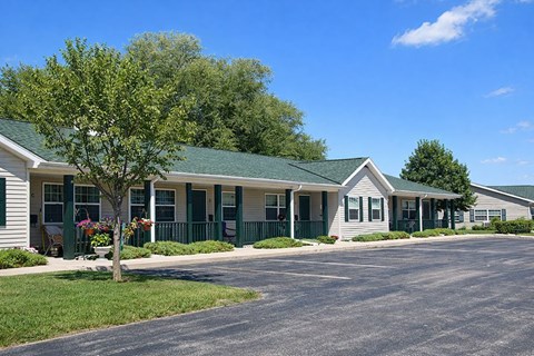 A small building with a green roof and white walls.