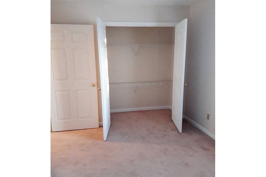an empty room with a closet and a door