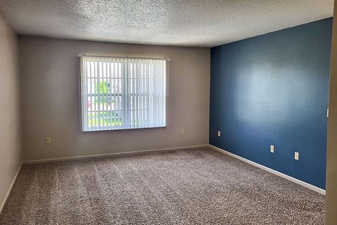 A room with a window and a car parked outside.