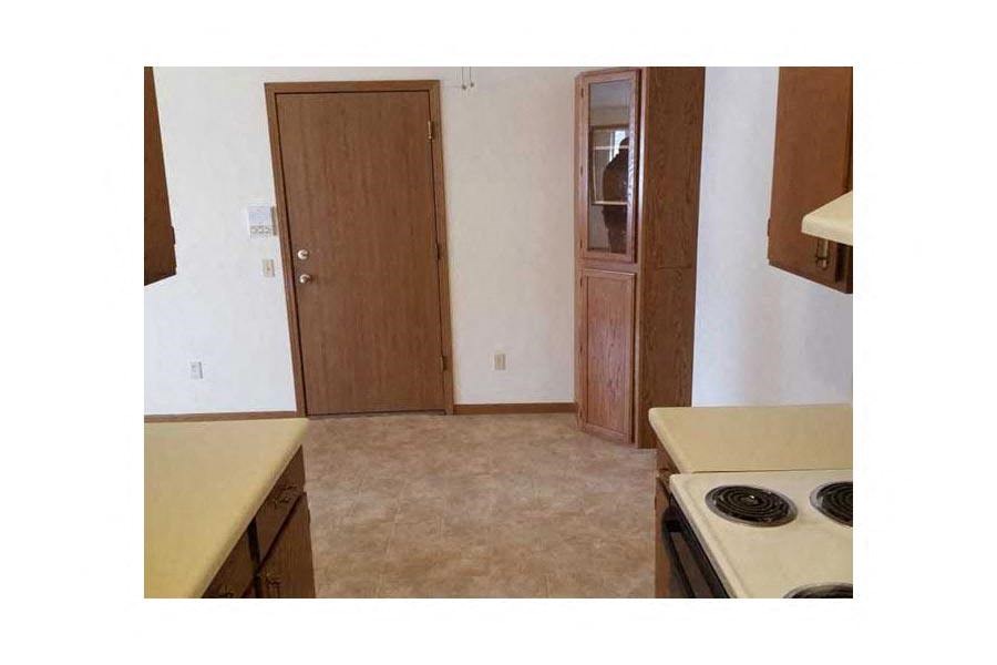 an empty kitchen with a stove and a door