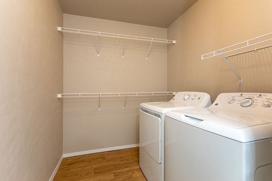 an empty laundry room with two washes and a dryer