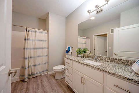 A bathroom with a toilet, sink, and shower.