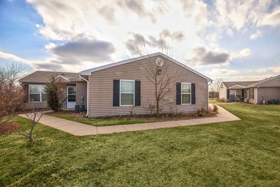 a house with a sidewalk in front of a grass yard