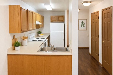 A kitchen with wooden cabinets and a white fridge.