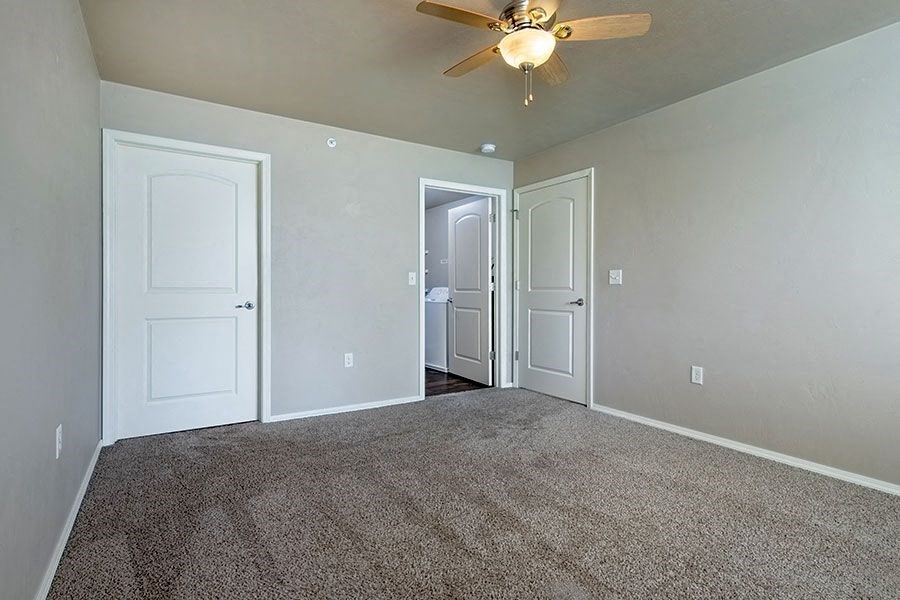 an empty living room with a ceiling fan
