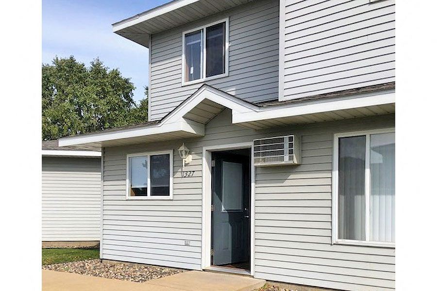 the front of a white house with a blue door