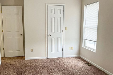 an empty room with a door and a window
