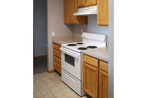 A white stove top oven with a black griddle on a kitchen counter.