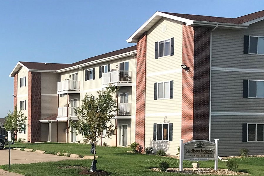 an apartment building with a sign in front of it