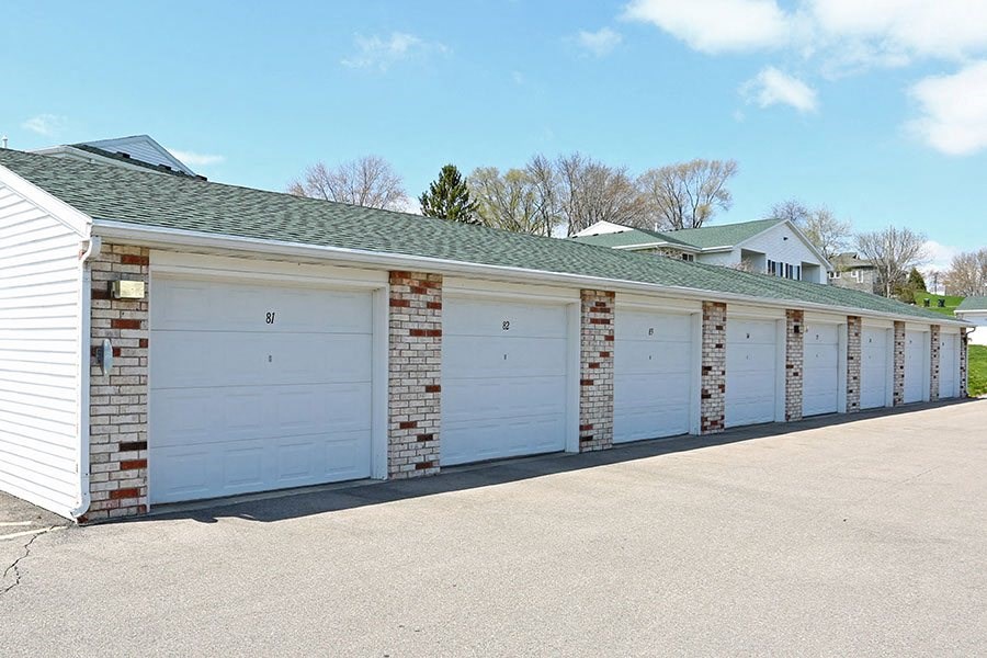 a row of white garage doors on the side of a building