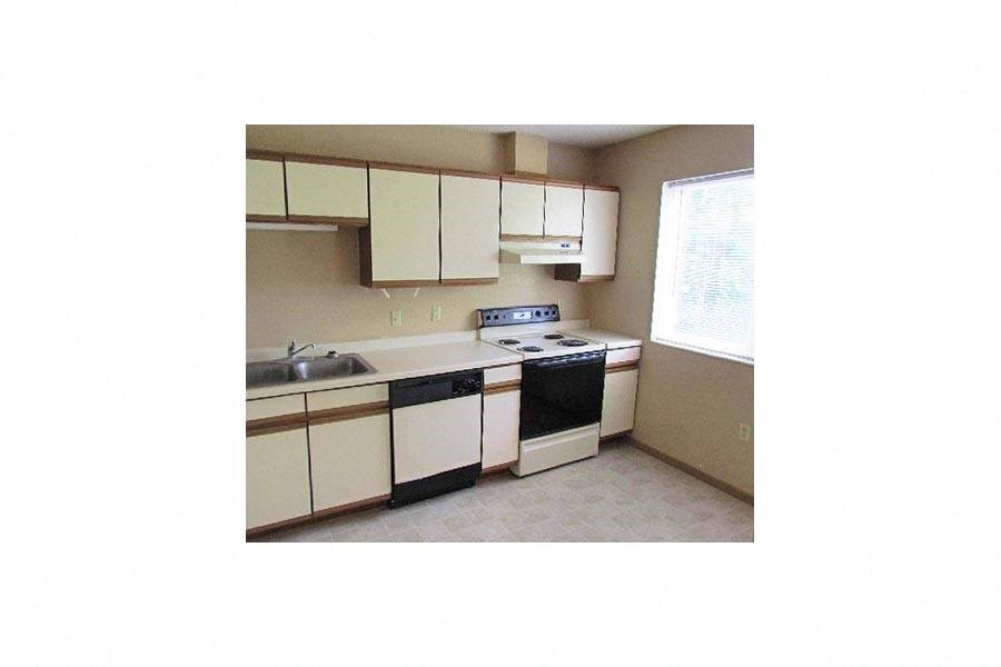 a kitchen with white cabinets and a stove and a sink