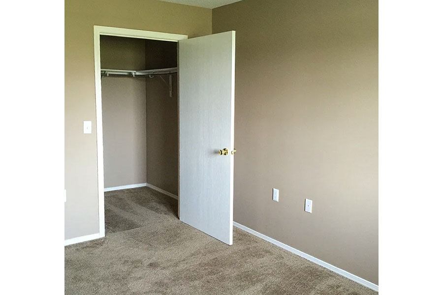 A room with a white door and carpeted floor.