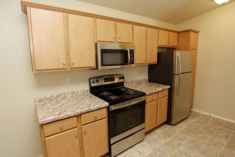 a kitchen with stainless steel appliances and granite counter tops