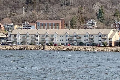 A row of houses are built on the shore of a body of water.
