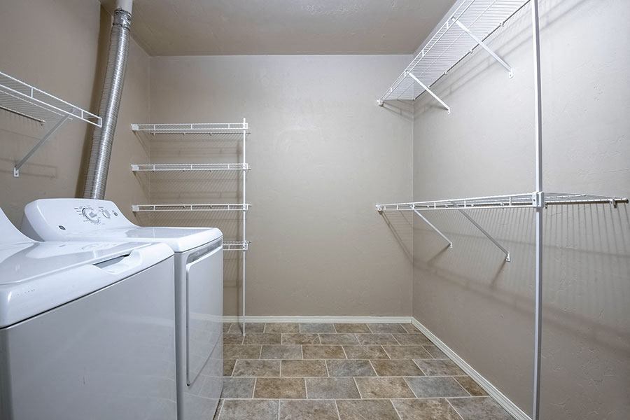 a closet with a dryer and a sink in a bathroom