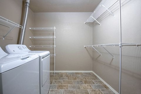 a closet with a dryer and a sink in a bathroom