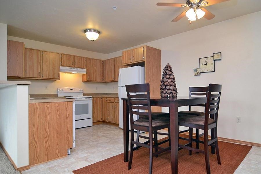 A kitchen with a table and chairs.