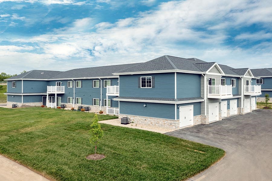 A row of houses with a blue sky and clouds in the background.