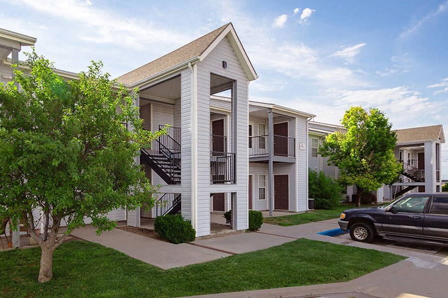 A white house with a black truck parked in front.