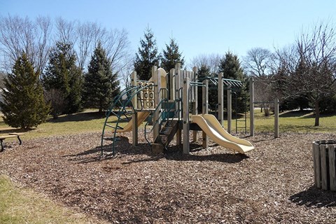 A playground with a slide and a climbing frame.