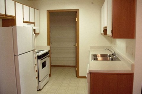 A kitchen with a white refrigerator and a white stove top oven.