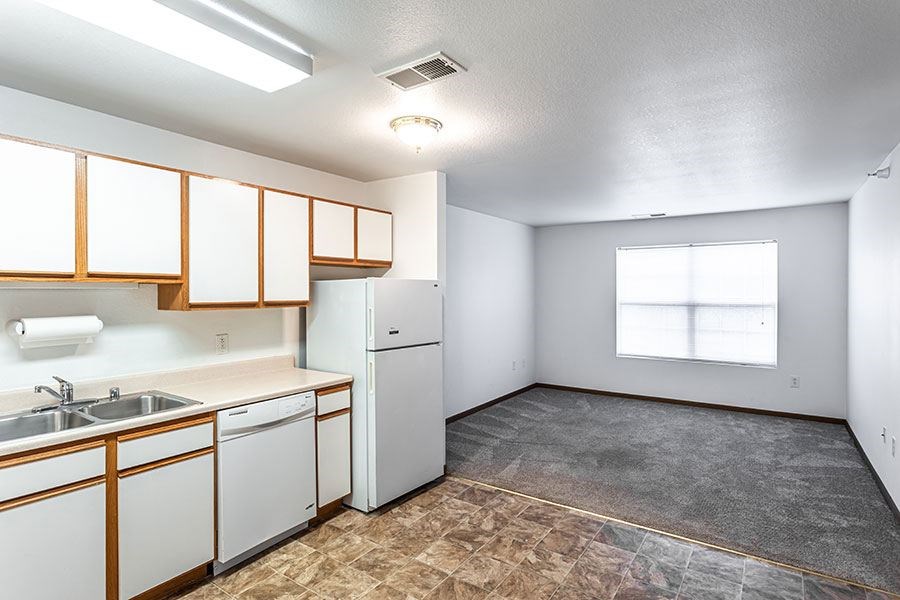 A kitchen with white cabinets and appliances.