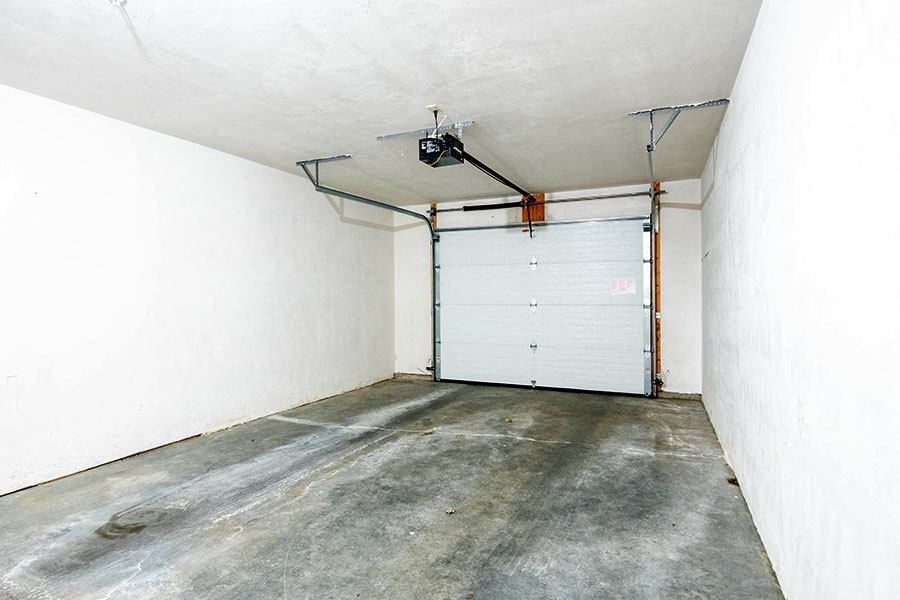 an empty garage with a white wall and a garage door
