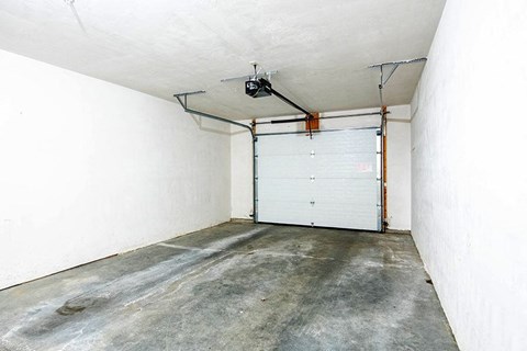 an empty garage with a white wall and a garage door