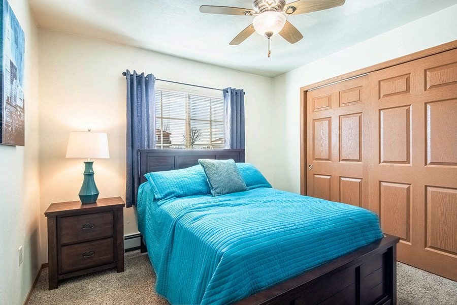 a bedroom with a bed and a ceiling fan