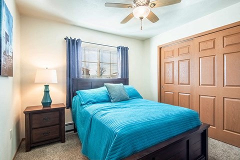 a bedroom with a bed and a ceiling fan
