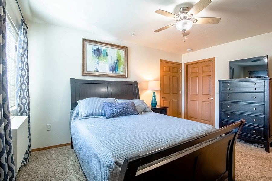 a bedroom with a large bed and a ceiling fan