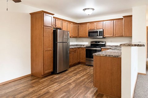 A kitchen with wooden cabinets and a granite countertop.