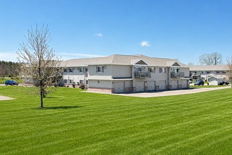 A large building with a green lawn in front of it.