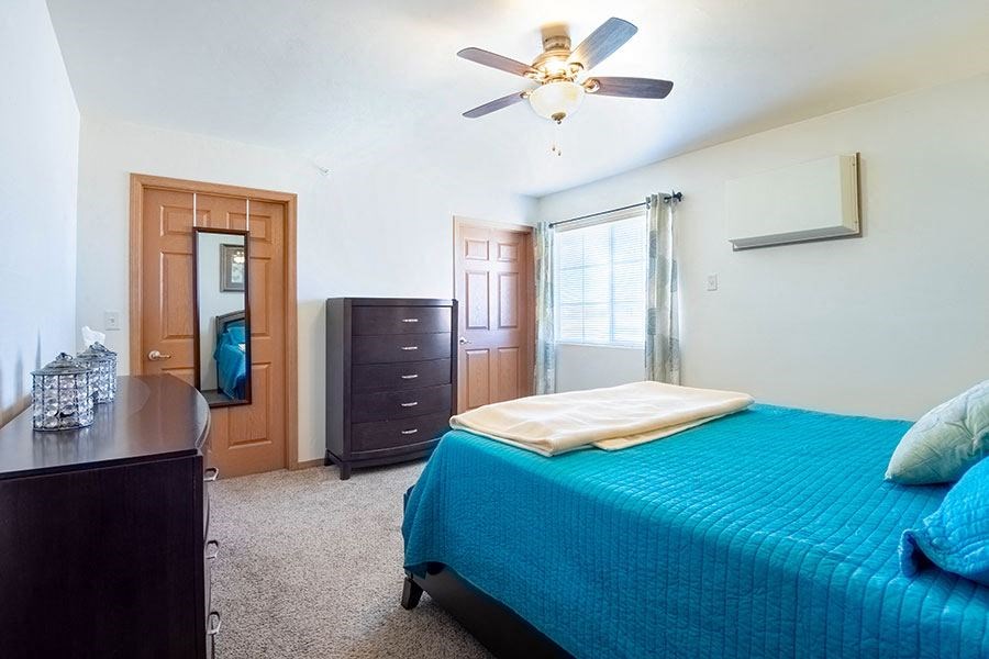 a bedroom with a bed and a ceiling fan