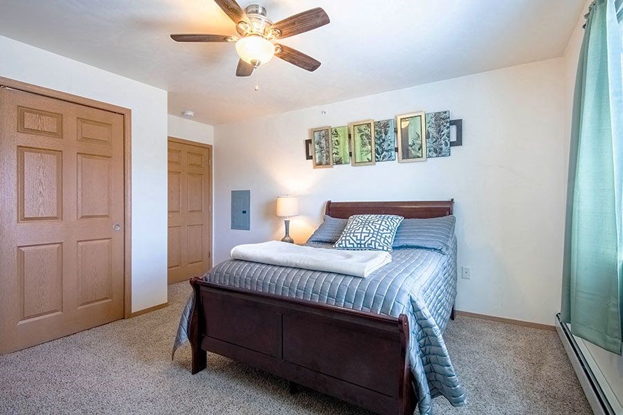 a bedroom with a bed and a ceiling fan