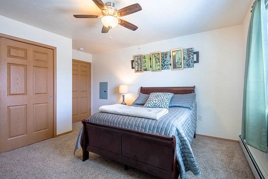a bedroom with a bed and a ceiling fan
