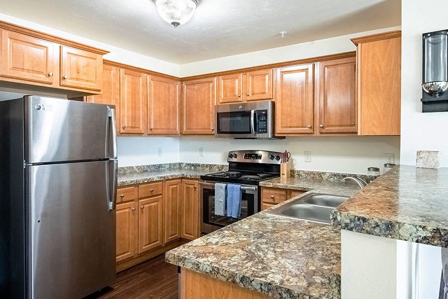 a kitchen with wooden cabinets and stainless steel appliances