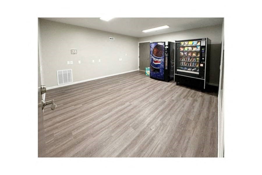 an empty room with a refrigerator and a door