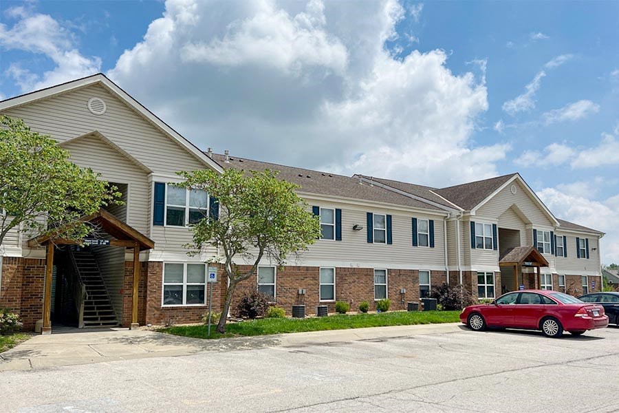 a red car parked in front of an apartment building
