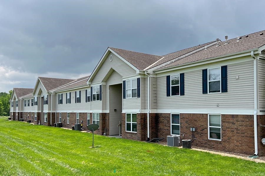 a row of houses sitting next to a green yard