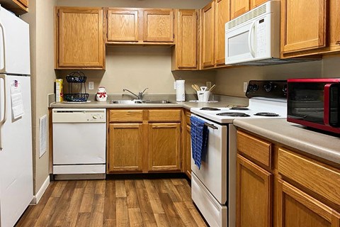 a kitchen with white appliances and wooden cabinets
