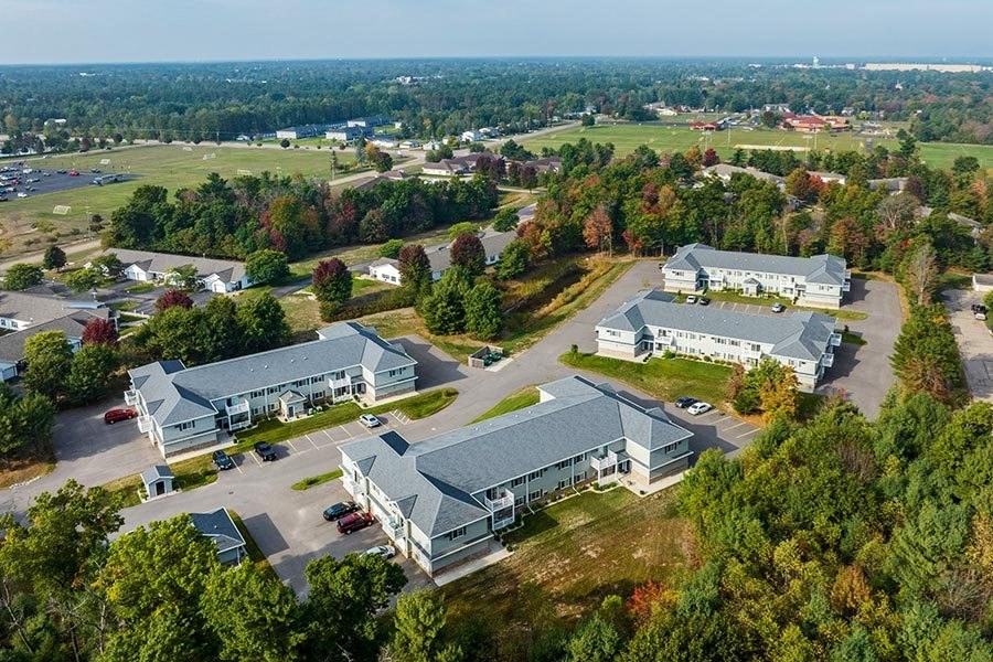 an aerial view of a group of houses in a parking lot